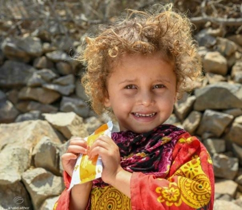 lockiges Kind mit Lebensmittelspende